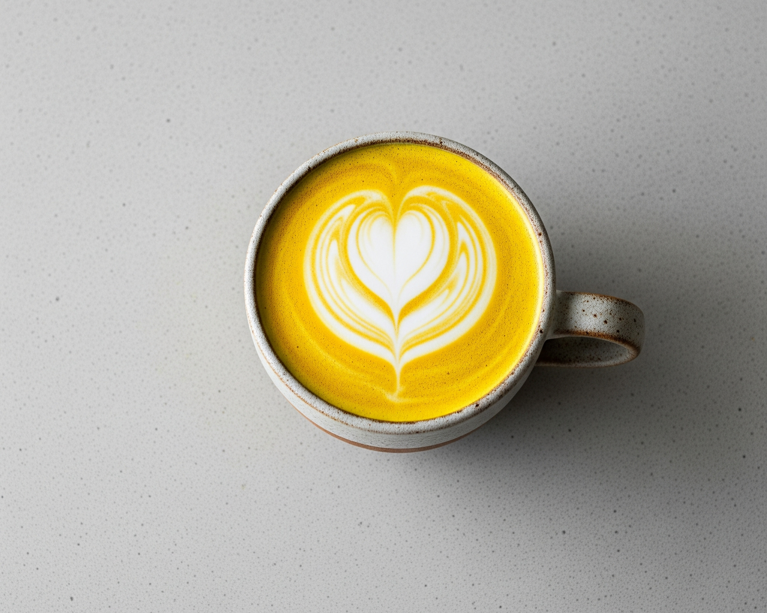 A turmeric latte on a grey kitchen countertop