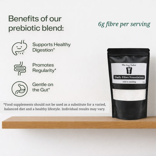 Black packaging of Daily Fibre Foundation on a wooden shelf with text about prebiotic benefits.