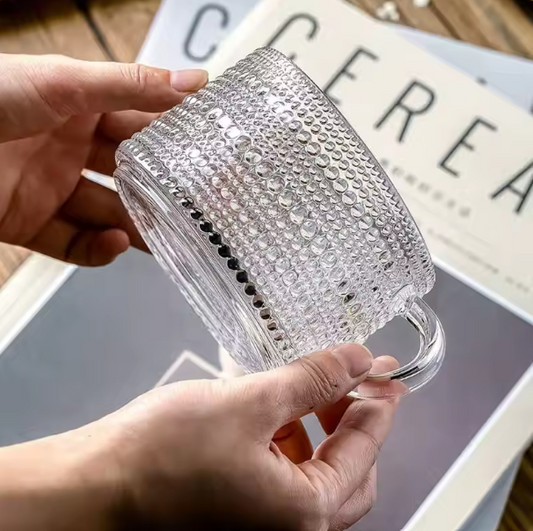 Someone holding a glass overnight oats mug