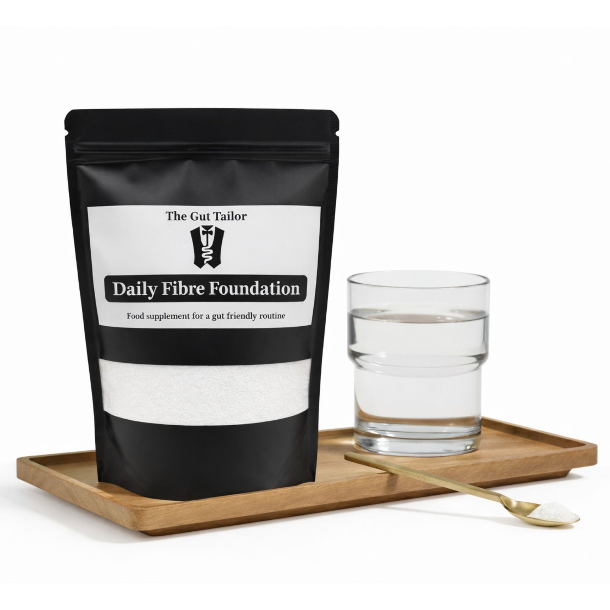 Bag of 'Daily Fibre Foundation' by The Gut Tailor on a wooden tray with a glass of water and spoon.