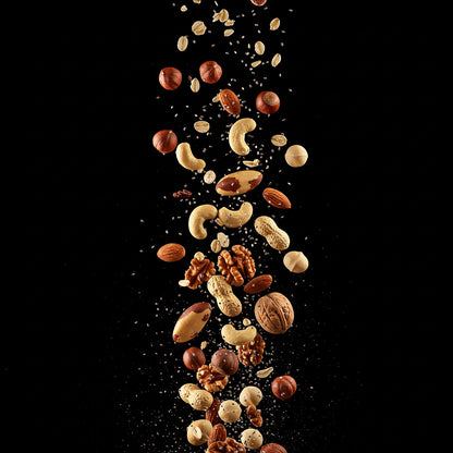 Different types of nuts falling on a black background to show the ingredients of the 7-nut prebiotic porridge recipe by the gut tailor