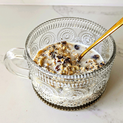Glass mug with cereal and milk on a marble surface