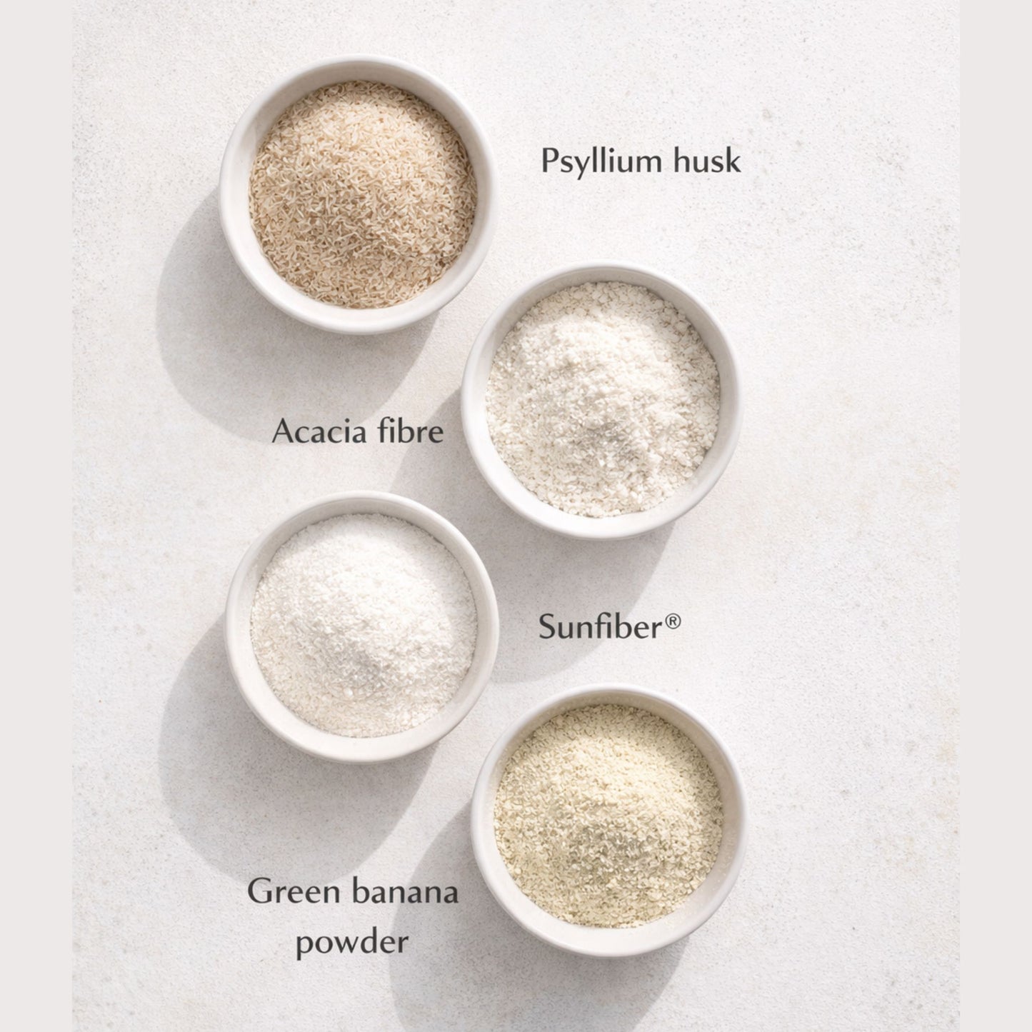 Four bowls of different fiber powders on a light background
