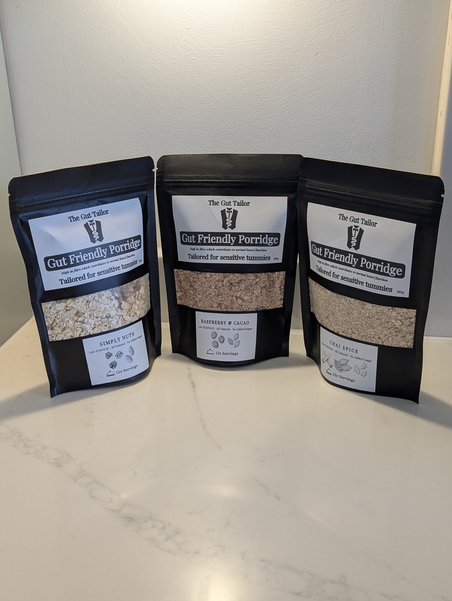 Three packages of Gut Friendly Porridge on a white surface with a neutral background