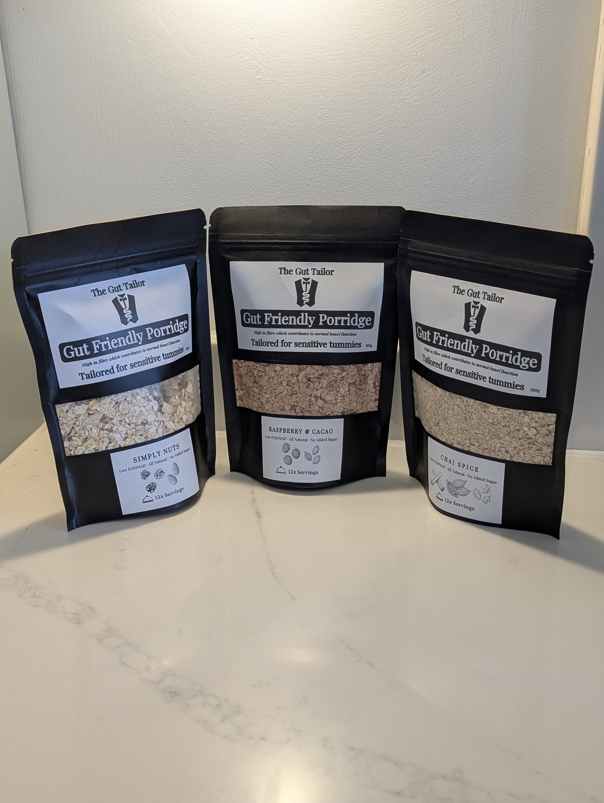 Three packages of Gut Friendly Porridge on a white surface with a neutral background
