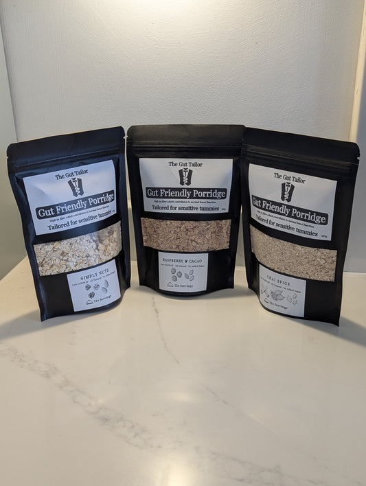 Three packages of Gut Friendly Porridge on a white surface with a neutral background